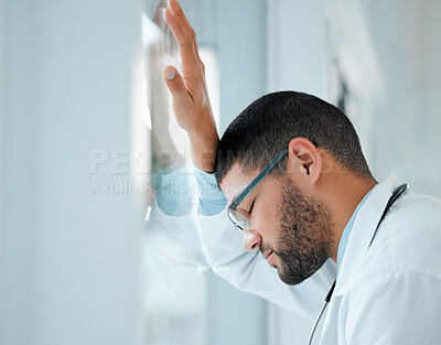 Buy stock photo shot of a young male doctor looking unhappy while at work at a hospital