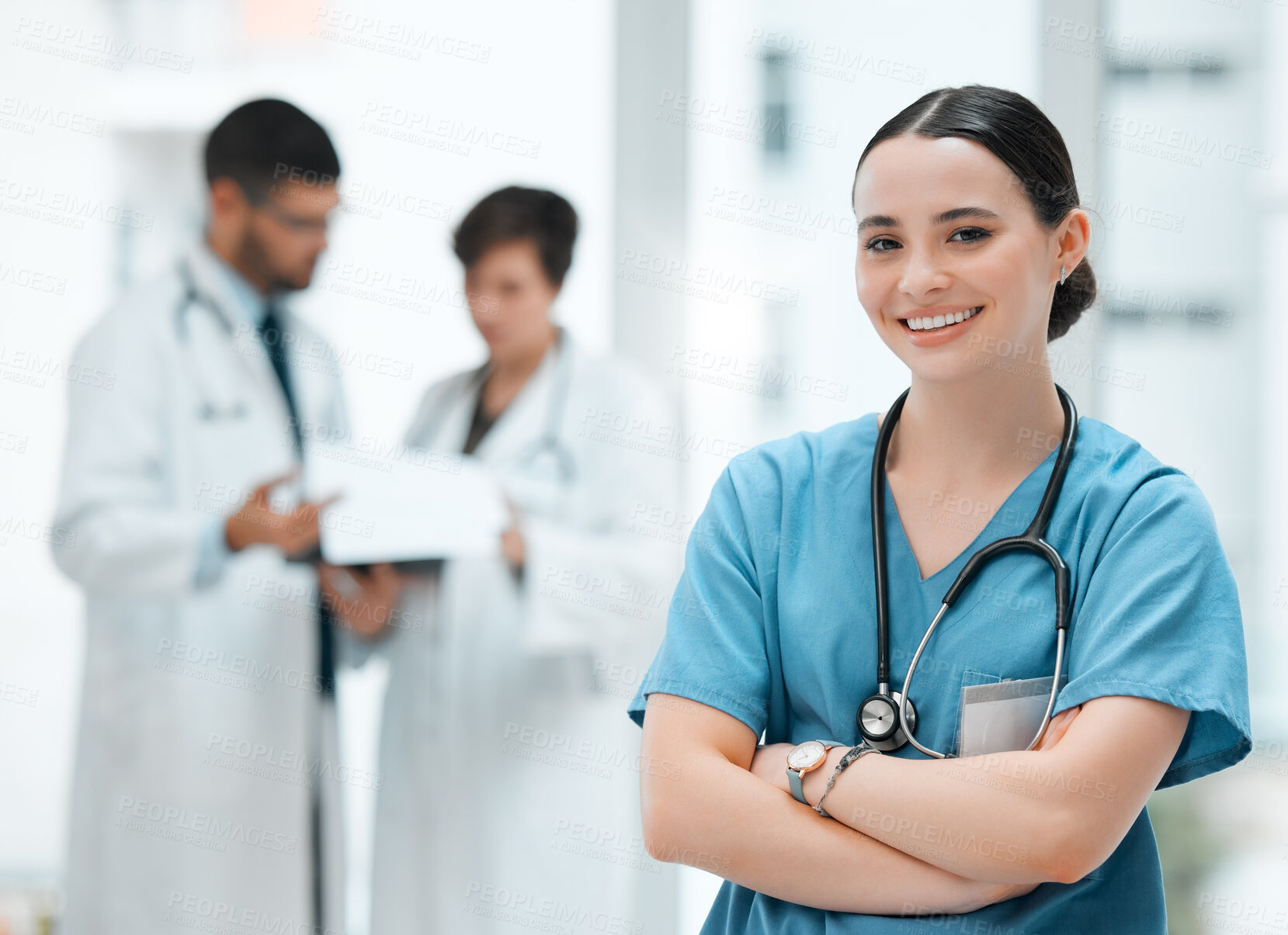 Buy stock photo Shot of a young female doctor standing with her arms crossed at a hospital