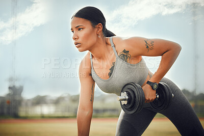 Buy stock photo Cropped shot of an attractive young female athlete exercising with dumbbells outdoors