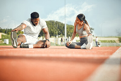 Buy stock photo Full length shot of a young athletic couple warming up before starting their outdoor exercise routine
