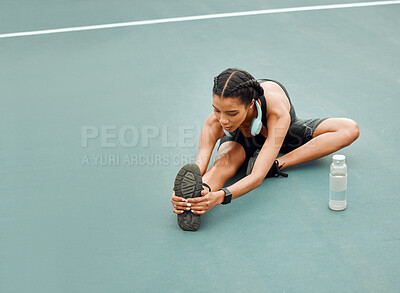 Buy stock photo High angle shot of an attractive young female athlete warming up outside before beginning her workout