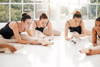 Buy stock photo Shot of a group of ballerinas warming up before practicing their routine
