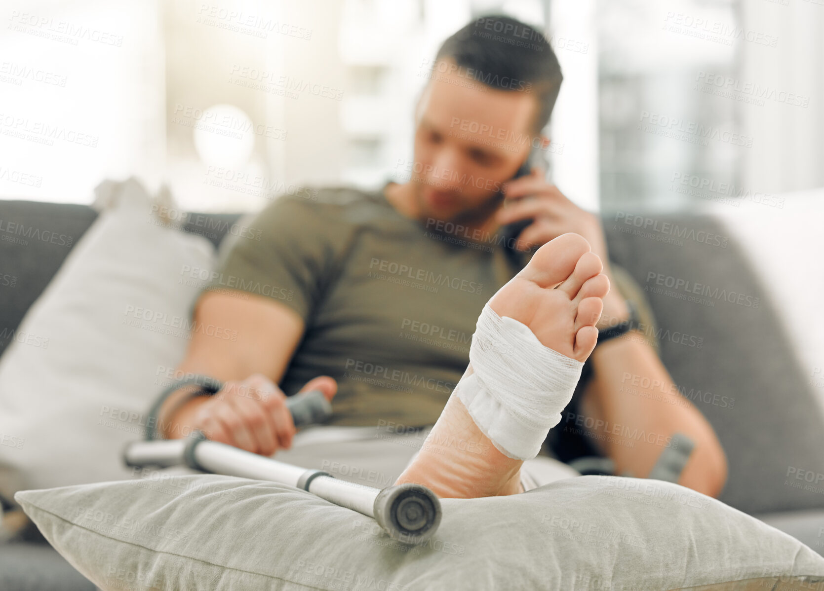 Buy stock photo Home, man and injury with broken, foot and bandage for inflammation rehabilitation with crutch. Closeup, apartment and guy with bruise, sprain and agony or ache for medical follow up in lounge