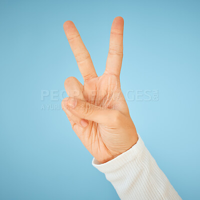 Buy stock photo Shot of an unrecognizable woman showing the peace sign against a blue background