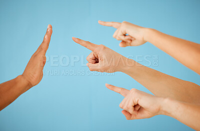 Buy stock photo Shot of an unrecognizable group of people pointing towards hand held out in a stopping gesture against a blue background