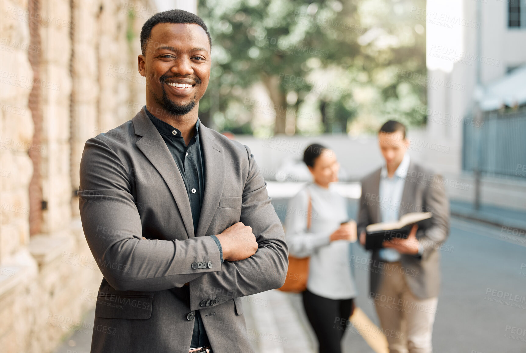 Buy stock photo Shot of a young businessman walking to work with his colleagues