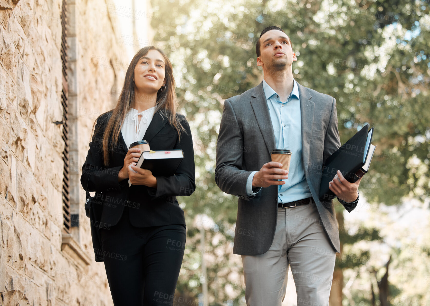 Buy stock photo Shot of two business colleagues walking together in the city