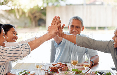 Buy stock photo Shot of a family giving each other a high five while having dinner together at home