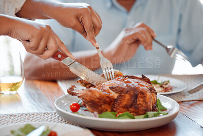 Buy stock photo Shot of an unrecognizable person cutting a chicken at the the dinner table at home
