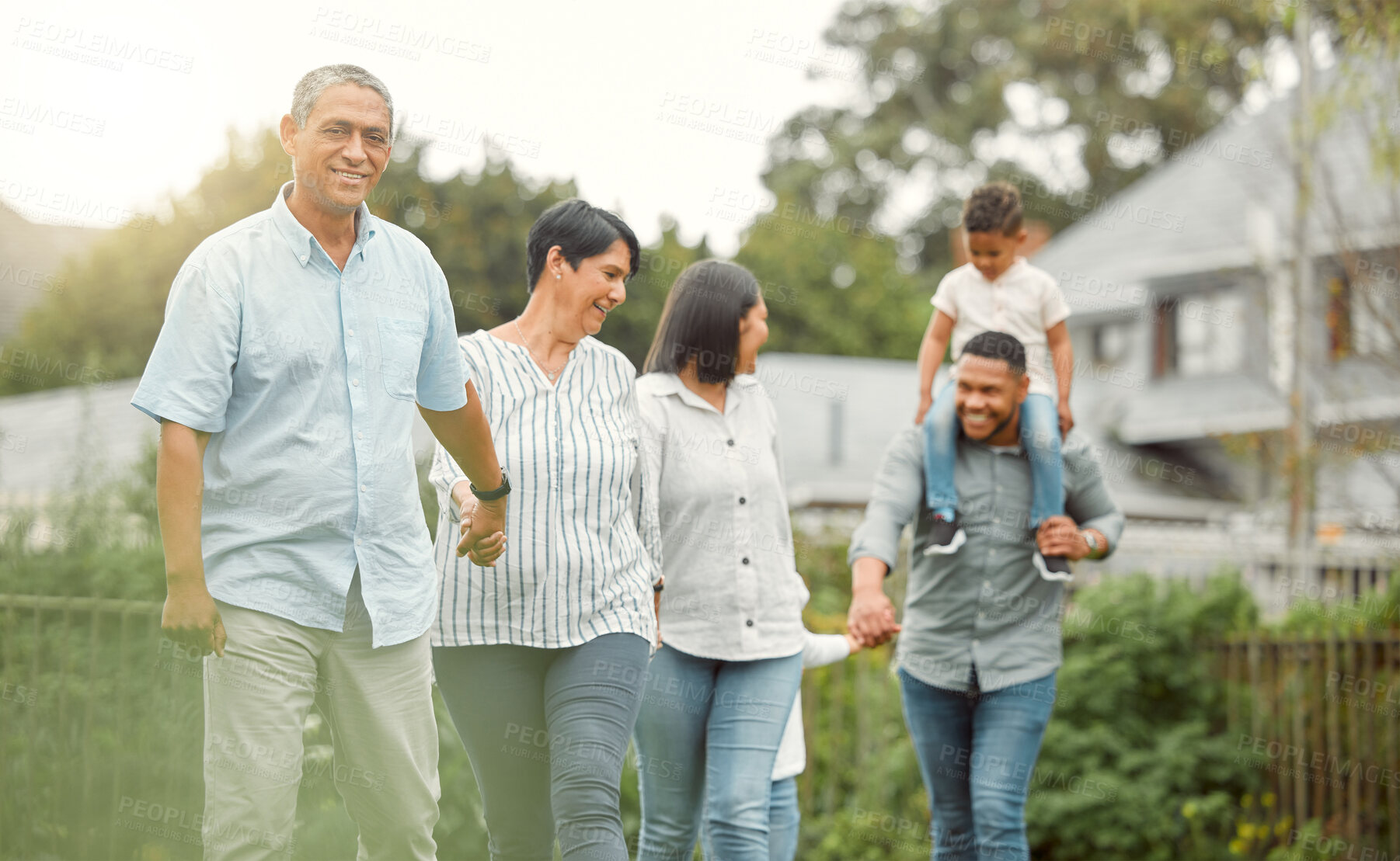 Buy stock photo Happy, big family and holding hands for walking outdoor with child on father shoulders, love and bonding. Smile, grandparents and children with care, support and playful, trust and explore garden