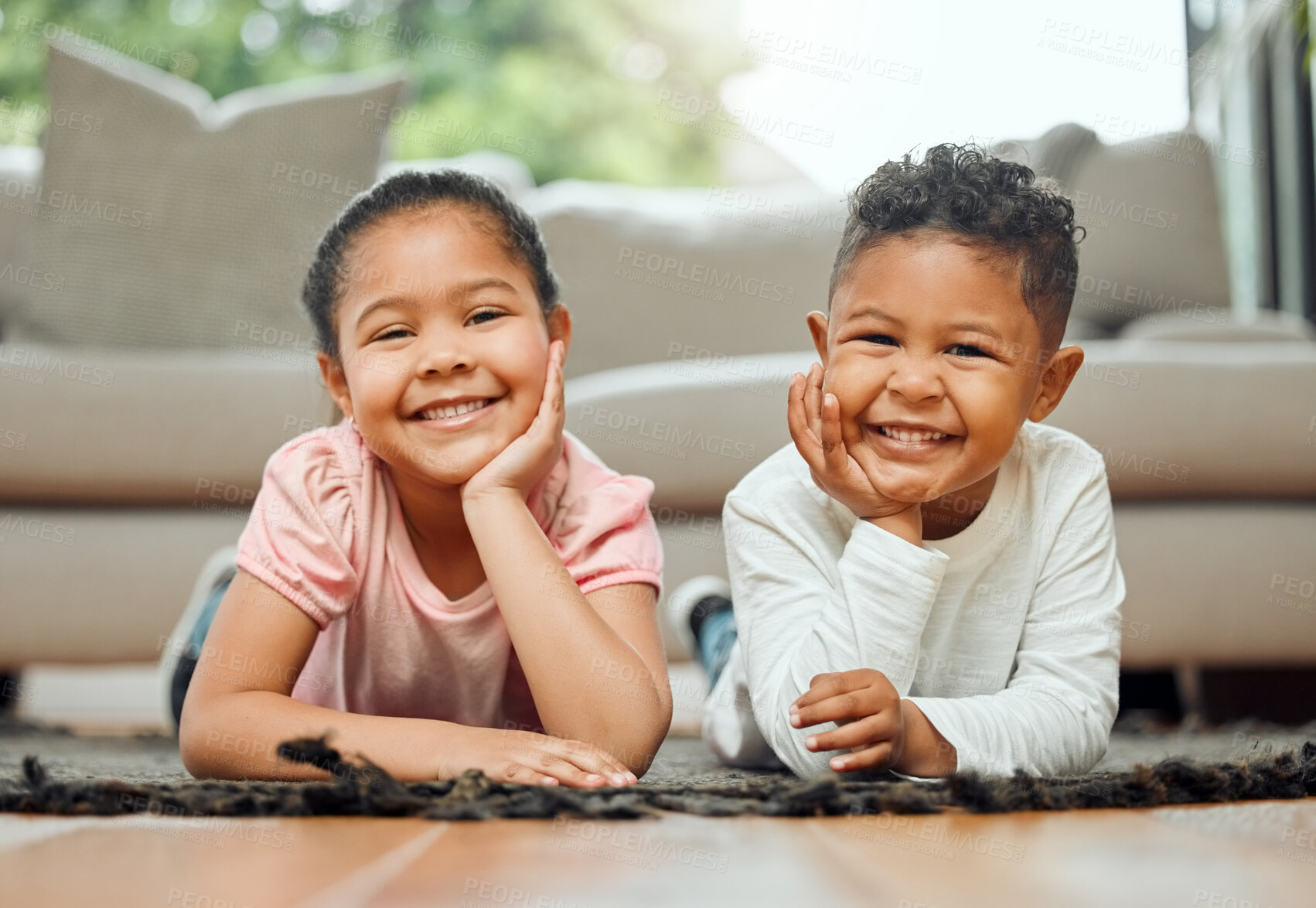 Buy stock photo Portrait of two young siblings lying on the floor together at home