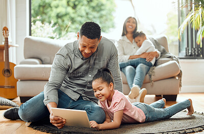 Buy stock photo Shot of a father and daughter using a digital tablet while the mother comforts the son in the background