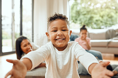 Buy stock photo Portrait of an adorable little boy opening his arms while his family bonds on the lounge floor in the background
