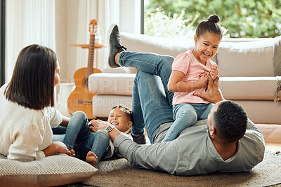 Buy stock photo Shot of a young family playing together on the lounge floor at home