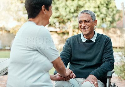 Buy stock photo Shot of an elderly couple being affectionate while sitting outside in a garden together