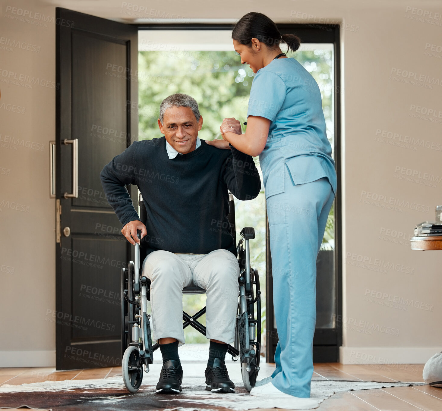 Buy stock photo Shot of a young nurse caring for an older man in a wheelchair