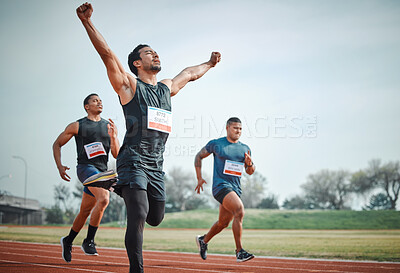 Buy stock photo Cropped shot of a handsome young male athlete celebrating his win during a race with his opponents in the background