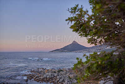 Buy stock photo Ocean view of sea water on rock beach, mountains and twilight sky with copy space of Lions Head in Cape Town, South Africa. Calm tide, serene or tranquil scenery of relaxing mother nature at sunrise