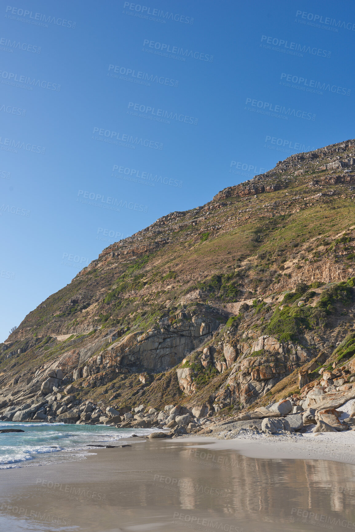 Buy stock photo Beautiful view of a nature landscape with the sea, sand, and a blue sky background. Natural outdoors setting of the beach and green mountains. Isolated environment outside near ocean water.