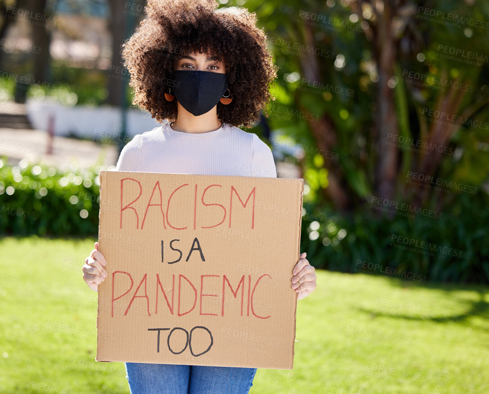 Buy stock photo Shot of a unrecognizable woman protesting outside in the park