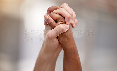 Buy stock photo Shot of two people united and holding hands at a protest