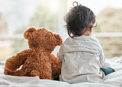 Buy stock photo Rearview shot of a baby girl sitting at home with her teddybear