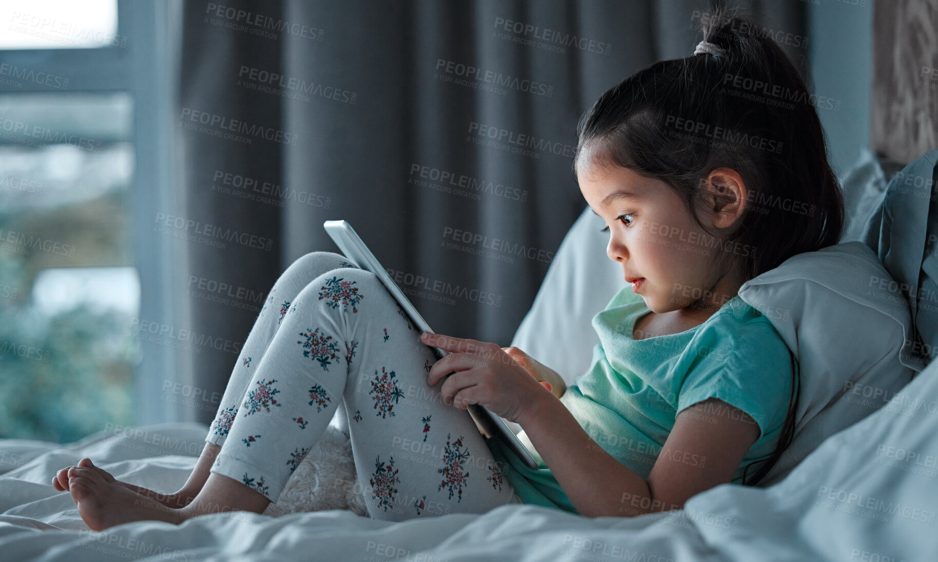 Buy stock photo Online, tablet and little girl on bed for education, learning or child development in bedroom. Digital, reading and asian kid with ebook subscription for information, literacy or knowledge in home