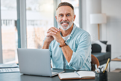 Buy stock photo Shot of a mature businessman sitting alone in his home office and using a laptop