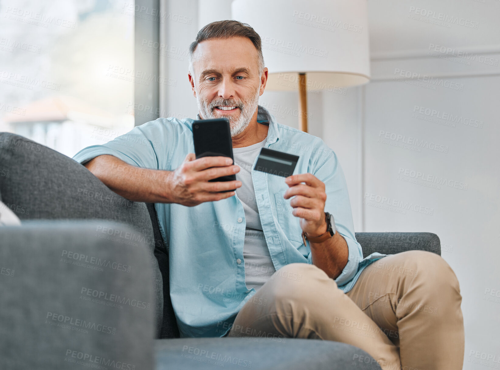 Buy stock photo Credit card, mobile phone and mature man on sofa for transaction, e commerce or online shopping in living room. Payment, smartphone and person for purchase, subscription or internet banking in home