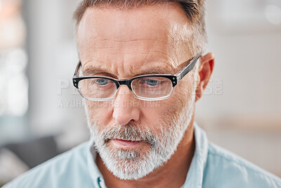 Buy stock photo Shot of a mature businessman looking contemplative while working in his office