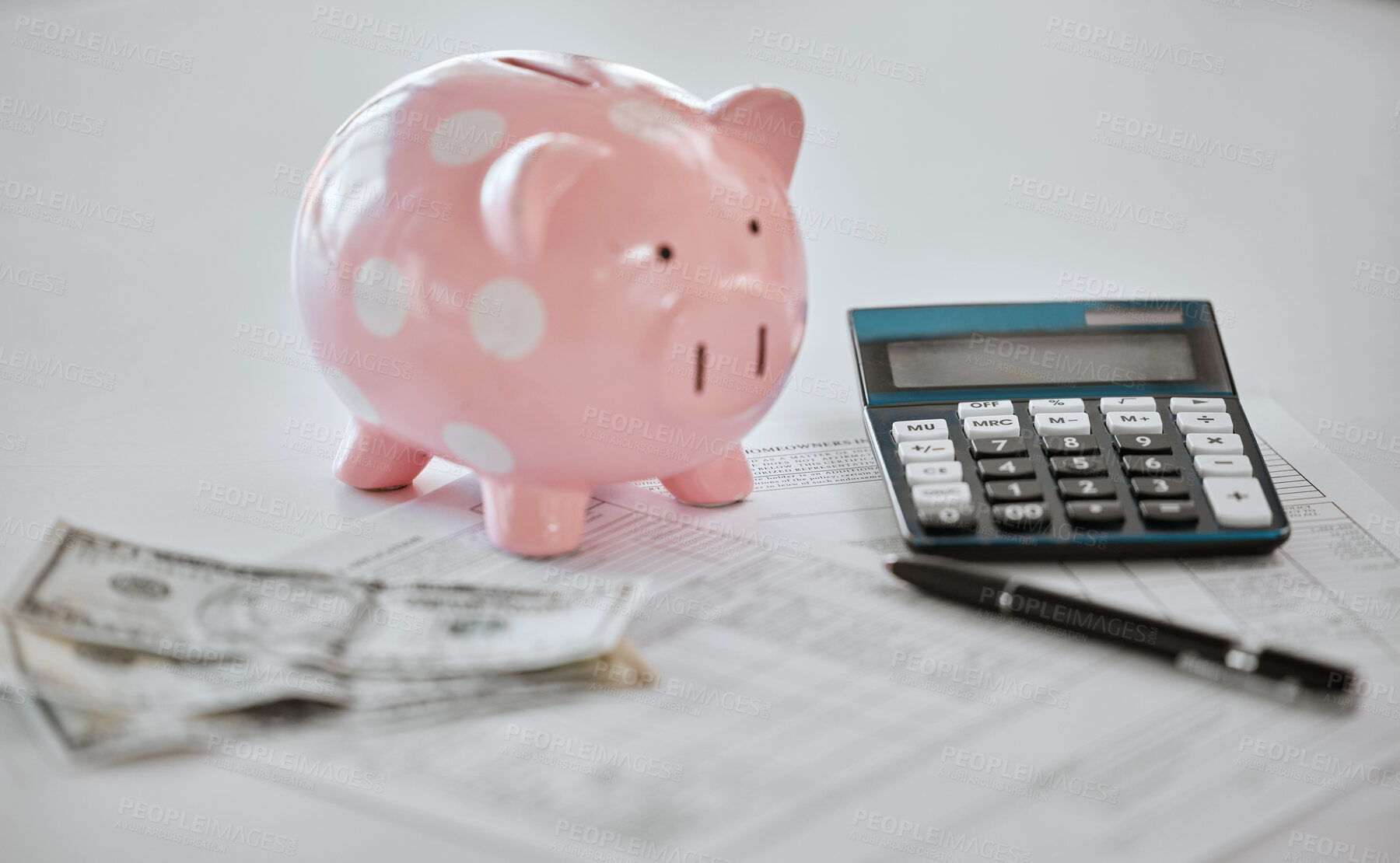 Buy stock photo Shot of a piggy bank on top of a contract and some money in a office