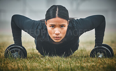 Buy stock photo Portrait of a sporty young woman exercising with dumbbells outdoors