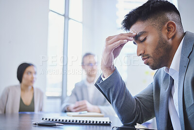 Buy stock photo Mental health, businessman with a headache and at a business meeting with colleagues in a boardroom office at their workplace. Stress or depression, anxiety or tired and sad male person at a desk