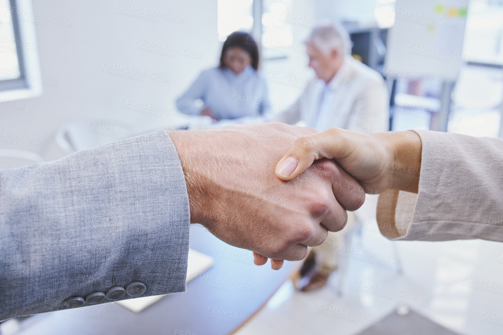Buy stock photo Cropped shot of two businesspeople shaking hands in a boardroom