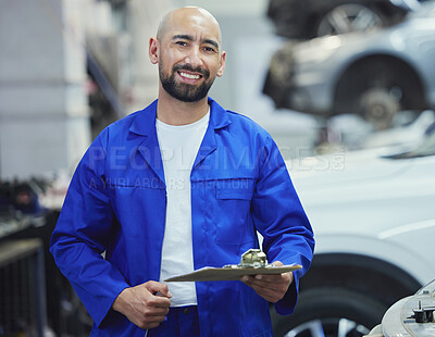 Buy stock photo Cropped portrait of a handsome young male mechanic working on the engine of a car during a service