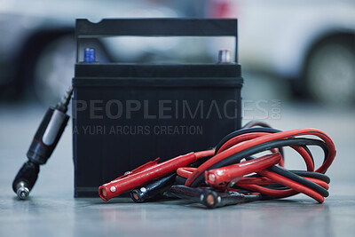 Buy stock photo Jumper cables, workshop and battery for car on floor for mechanical service with repairs or maintenance. Career, industry and vehicle electricity cell for power, voltage or charge in motor garage.