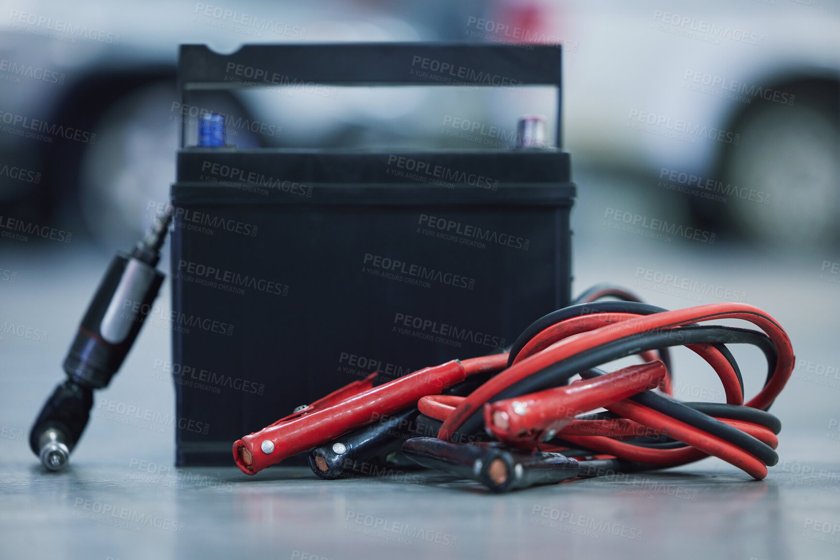 Buy stock photo Jumper cables, workshop and battery for car on floor for mechanical service with repairs or maintenance. Career, industry and vehicle electricity cell for power, voltage or charge in motor garage.