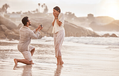 Buy stock photo Couple at beach, surprise proposal and engagement with love and commitment with ocean and people outdoor. Travel, seaside and man propose marriage to woman, wow reaction and happiness with care