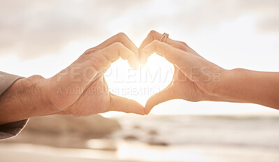 Buy stock photo Shot of an unrecognizable couple making a heart gesture with their hands at the beach