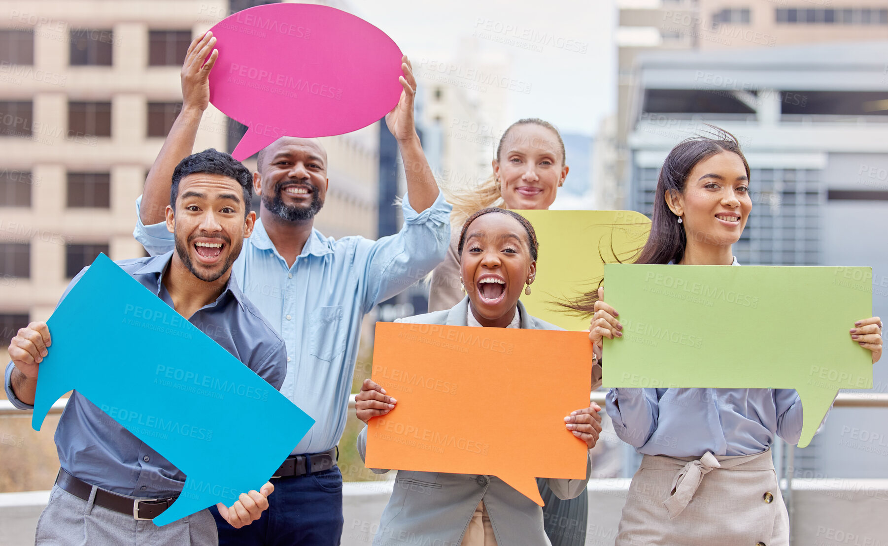 Buy stock photo Shot of a group of young businesspeople holding speech bubbles against a city background