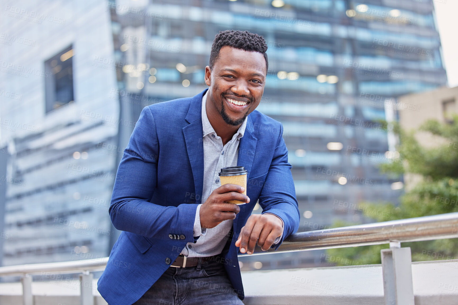 Buy stock photo Shot of a young businessman drinking a cup of coffee against a city background