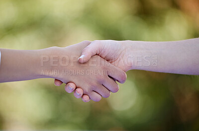 Buy stock photo Cropped shot of two unrecognizable businesswomen shaking hands while standing outside