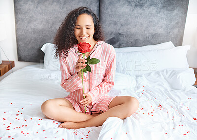 Buy stock photo Happy, woman and flower in bedroom for love, care and romance or present on weekend morning. Female person, smile and rose in home with pyjamas on for relax, comfort, and relationship or gift