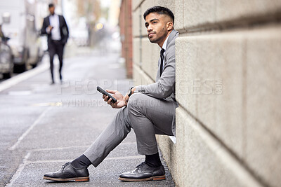 Buy stock photo Thinking, phone and a businessman sitting in the city for social media, communication or email. Contact, ideas and a corporate person in a suit with a mobile for a chat, internet or notification