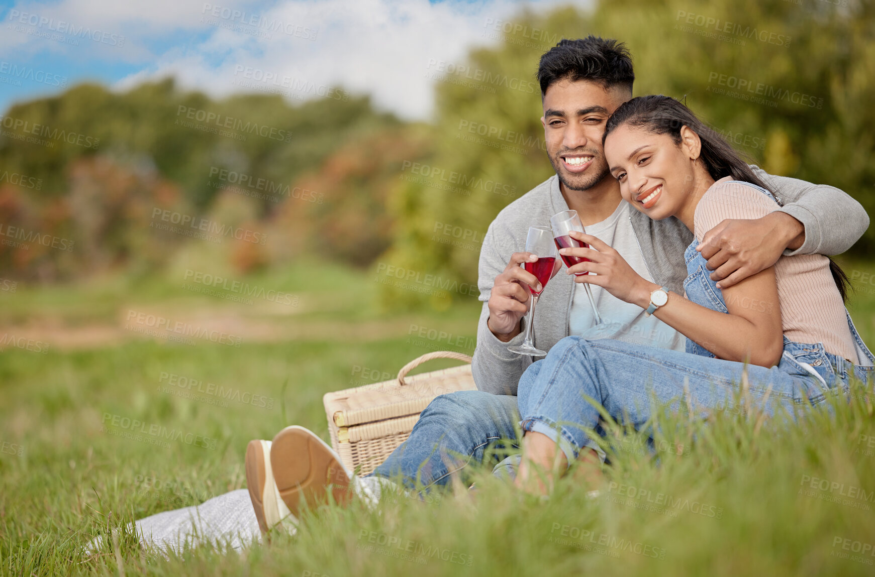 Buy stock photo Couple, picnic and glass in park for love with celebrate anniversary, alcohol toast and basket with food. Woman, man and happiness in nature with cheers, wine drink and weekend date for relationship