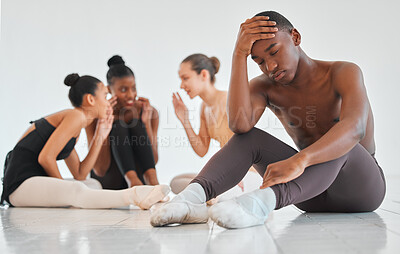 Buy stock photo Shot of a teenage boy looking sad while the rest of his ballet class talks about him behind his back