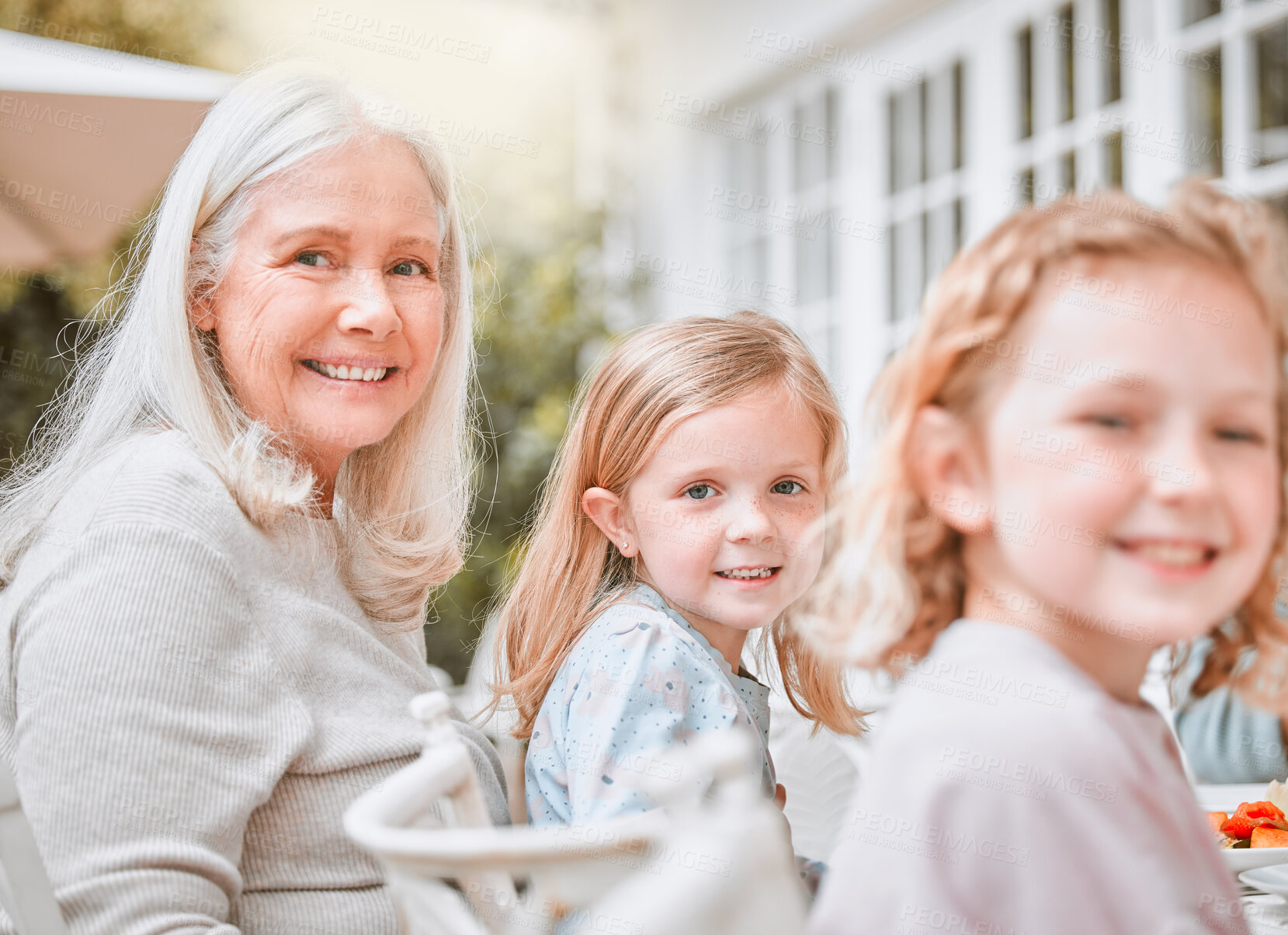 Buy stock photo Girls, grandmother and portrait with bonding outdoor for lunch, family reunion and celebration with smile. Children, senior woman and happy kids by table on patio for brunch, relax and social event