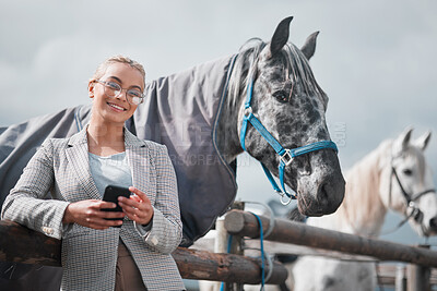 Buy stock photo Portrait of an attractive woman using her cellphone while posing with a horse in an enclosed pasture on a farm