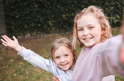 Buy stock photo Shot of two adorable little girls taking selfies in a garden