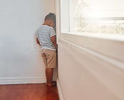 Buy stock photo Shot of an unrecognizable little boy facing the wall and as punishment in a room at home